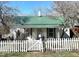 Charming home featuring a picket fence and a vibrant green metal roof at 108 Holt St, Hillsborough, NC 27278