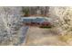 Aerial view of a single-Gathering home with an attached garage, a long driveway, and surrounded by trees at 1117 Pine Trl, Clayton, NC 27520