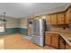 Bright eat-in kitchen featuring stainless steel refrigerator and wood cabinets at 1117 Pine Trl, Clayton, NC 27520