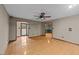 Open-concept living room featuring hardwood floors, multiple entryways, a ceiling fan, and neutral colored walls at 1117 Pine Trl, Clayton, NC 27520