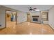 Open-concept living room featuring hardwood floors, a fireplace, and a ceiling fan with views into the kitchen at 1117 Pine Trl, Clayton, NC 27520