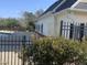 Side exterior view of a cream colored building with white trim, adjacent to a fenced-in community pool at 1208 Shining Water Ln, Creedmoor, NC 27522