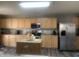 Well-lit kitchen with light wood cabinets, stainless steel appliances, and island at 1208 Shining Water Ln, Creedmoor, NC 27522