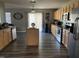 Spacious kitchen boasting an island, stainless steel appliances, and wood-look floors at 1208 Shining Water Ln, Creedmoor, NC 27522