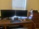 Office setup featuring a desk with dual monitors and a rolling desk chair at 1208 Shining Water Ln, Creedmoor, NC 27522
