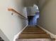 Carpeted stairs leading to the upper level featuring a wooden handrail and updated flooring at the landing at 1208 Shining Water Ln, Creedmoor, NC 27522