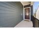 Home's front entrance with a covered porch, dark wood door, and black railings at 1215 White Flint Cir, Durham, NC 27703