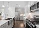 Bright kitchen with stainless steel appliances, gray cabinetry, and farm sink at 1215 White Flint Cir, Durham, NC 27703