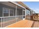 View of screen porch on a bright day, showing the outdoor living space with a railing and windows at 1215 White Flint Cir, Durham, NC 27703