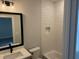 Bathroom with white vanity and black framed mirror; tub and shower combo with white subway tile at 122 Sanderway Dr, Chapel Hill, NC 27516