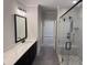 Modern bathroom with black vanity, white counter top, black framed mirror, and glass shower with gray tile at 122 Sanderway Dr, Chapel Hill, NC 27516
