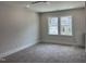 Bright bedroom featuring plush carpeting, recessed lighting, a ceiling fan, and double windows with views of the home across the street at 122 Sanderway Dr, Chapel Hill, NC 27516
