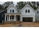Charming two-story home with a covered porch, an attached two-car garage, and stylish gray siding at 122 Sanderway Dr, Chapel Hill, NC 27516