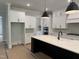 Bright kitchen with a large island, white cabinets, modern lighting, and updated appliances at 122 Sanderway Dr, Chapel Hill, NC 27516