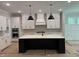 Modern kitchen featuring an island, custom cabinets, stylish light fixtures, and stainless steel appliances at 122 Sanderway Dr, Chapel Hill, NC 27516