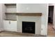 Living room featuring a fireplace with a light gray tile surround, a black framed firebox, and custom built-in shelving at 122 Sanderway Dr, Chapel Hill, NC 27516