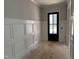 Living room featuring wainscoting, neutral gray paint, beautiful hardwood door, and clean design at 122 Sanderway Dr, Chapel Hill, NC 27516