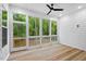 Screened-in porch with wood flooring, a ceiling fan, and a view of the surrounding trees at 122 Sanderway Dr, Chapel Hill, NC 27516