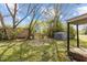 View of the home's backyard featuring a storage shed and mature trees at 128 Warren Ave, Oxford, NC 27565