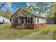 Charming house featuring brick accents, neutral siding, a cozy porch, and a well-kept lawn, exuding curb appeal at 128 Warren Ave, Oxford, NC 27565