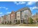 A row of brick and siding townhouses with manicured landscaping sits under a sky with scattered clouds at 131 Dove Cottage Ln, Cary, NC 27519