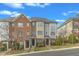 A row of attractive townhouses boasts brick and neutral siding, small front yards, and well-manicured landscaping at 131 Dove Cottage Ln, Cary, NC 27519