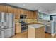 Well-lit kitchen boasts stainless steel appliances, tile backsplash, and a functional island at 131 Dove Cottage Ln, Cary, NC 27519