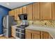 Well lit kitchen featuring wood cabinets, stainless steel appliances, and a mosaic backsplash at 131 Dove Cottage Ln, Cary, NC 27519
