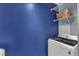 Laundry area includes a blue accent wall, shelving, and a modern washer/dryer at 131 Dove Cottage Ln, Cary, NC 27519