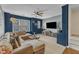 Comfortable living room with plush sectional sofa, ceiling fan, and large windows for natural light at 131 Dove Cottage Ln, Cary, NC 27519