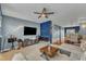 Living room features a ceiling fan, sofa, hardwood floors, built-in shelving, and a flatscreen TV at 131 Dove Cottage Ln, Cary, NC 27519