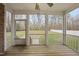 Screened-in back porch with wooden floors and a view of the expansive backyard and mature trees at 1320 Blue Heron Dr, Nashville, NC 27856