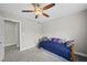 Neutral bedroom with a ceiling fan and carpeted floors features a cozy daybed and a glimpse into the closet at 1320 Blue Heron Dr, Nashville, NC 27856