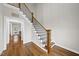 Inviting foyer with hardwood floors, staircase with wooden handrail and metal spindles, and a welcoming welcome sign on the wall at 1320 Blue Heron Dr, Nashville, NC 27856