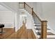 Bright foyer showcasing hardwood floors, open doorways, staircase with wooden handrail and metal spindles, and neutral paint at 1320 Blue Heron Dr, Nashville, NC 27856