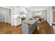 Open-concept kitchen featuring granite countertops, a gray island, white cabinetry, and stainless-steel appliances, perfect for cooking at 1320 Blue Heron Dr, Nashville, NC 27856