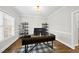 Well-lit office featuring a modern desk, shelving units, and a checkered rug, all complemented by natural light from the window at 1320 Blue Heron Dr, Nashville, NC 27856