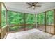 Relaxing covered patio with wood flooring and ceiling fan overlooking lush greenery at 1354 Red Bud Ct, Wake Forest, NC 27587