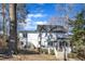 Exterior view of a white home with a wooden deck, pergola, and lush backyard with mature trees at 14 Wedgewood Pl, Clayton, NC 27527
