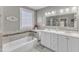 Elegant bathroom featuring double sinks, a soaking tub, and neutral tones at 14 Wedgewood Pl, Clayton, NC 27527
