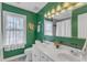 Stylish bathroom featuring double sinks, green walls, and modern lighting at 14 Wedgewood Pl, Clayton, NC 27527