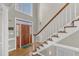 Welcoming foyer featuring a wood front door, hardwood floors, and elegant staircase at 14 Wedgewood Pl, Clayton, NC 27527