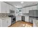Updated kitchen with stainless steel appliances, granite counters, and white cabinetry at 14 Wedgewood Pl, Clayton, NC 27527