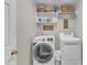 Functional laundry room with front-load washer, dryer, built-in shelving, and charming decor at 14 Wedgewood Pl, Clayton, NC 27527