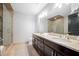 Bathroom featuring double sinks, marble counters, wood cabinets, and a glass shower at 140 W Franklin St # 406, Chapel Hill, NC 27516