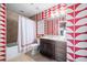 Bathroom featuring colorful wallpaper, stylish decor, and a vanity with under sink storage at 140 W Franklin St # 406, Chapel Hill, NC 27516