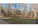 Spacious backyard with mature trees, wooden fence, and a glimpse of the home's exterior at 155 Georgetown Woods Dr, Youngsville, NC 27596