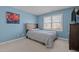 A cozy bedroom featuring a comfortable bed and natural light from a large window at 155 Georgetown Woods Dr, Youngsville, NC 27596