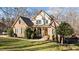 Elegant brick home with a lush green lawn, framed by well-maintained bushes and mature trees creating curb appeal at 155 Georgetown Woods Dr, Youngsville, NC 27596
