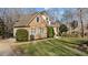 Beautiful brick home featuring manicured landscaping, lush green lawn, and charming curb appeal at 155 Georgetown Woods Dr, Youngsville, NC 27596